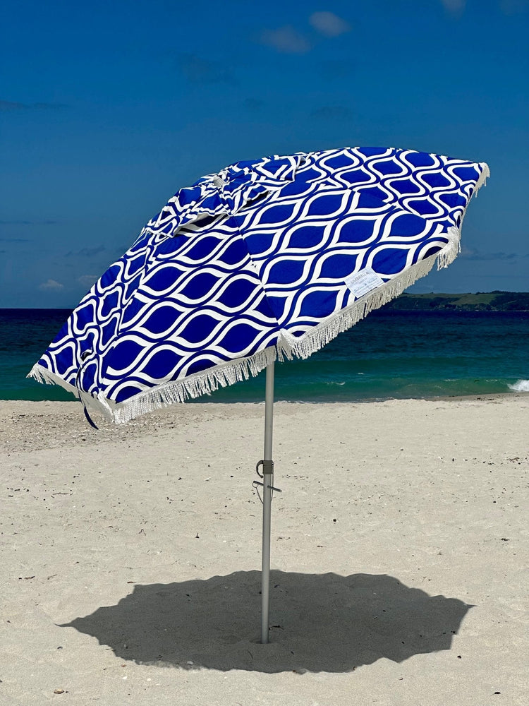 Classic Fringe Beach Umbrella Moroccan Blue with cotton fringe on sandy beach