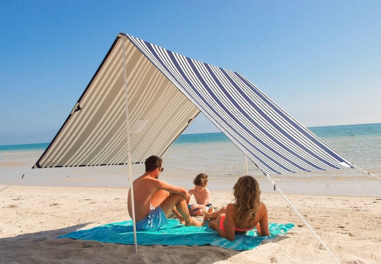 Lovin Summer beach shade tent with blue and white stripes providing UPF 40 sun protection on sandy beach