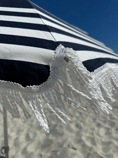 Hollie & Harrie Classic Fringe 210cm Canvas Beach Umbrella - Hello SaiWow the Hello Sailor is a Classic. 
The Fringe 210cm Beach Umbrella is a classic beach lovers staple. The thick &amp; luxurious 100% cotton canopy with a retro fringBeachkit