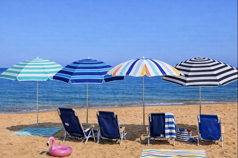 Beach scene with colorful umbrellas and lounge chairs on a sandy beach.
