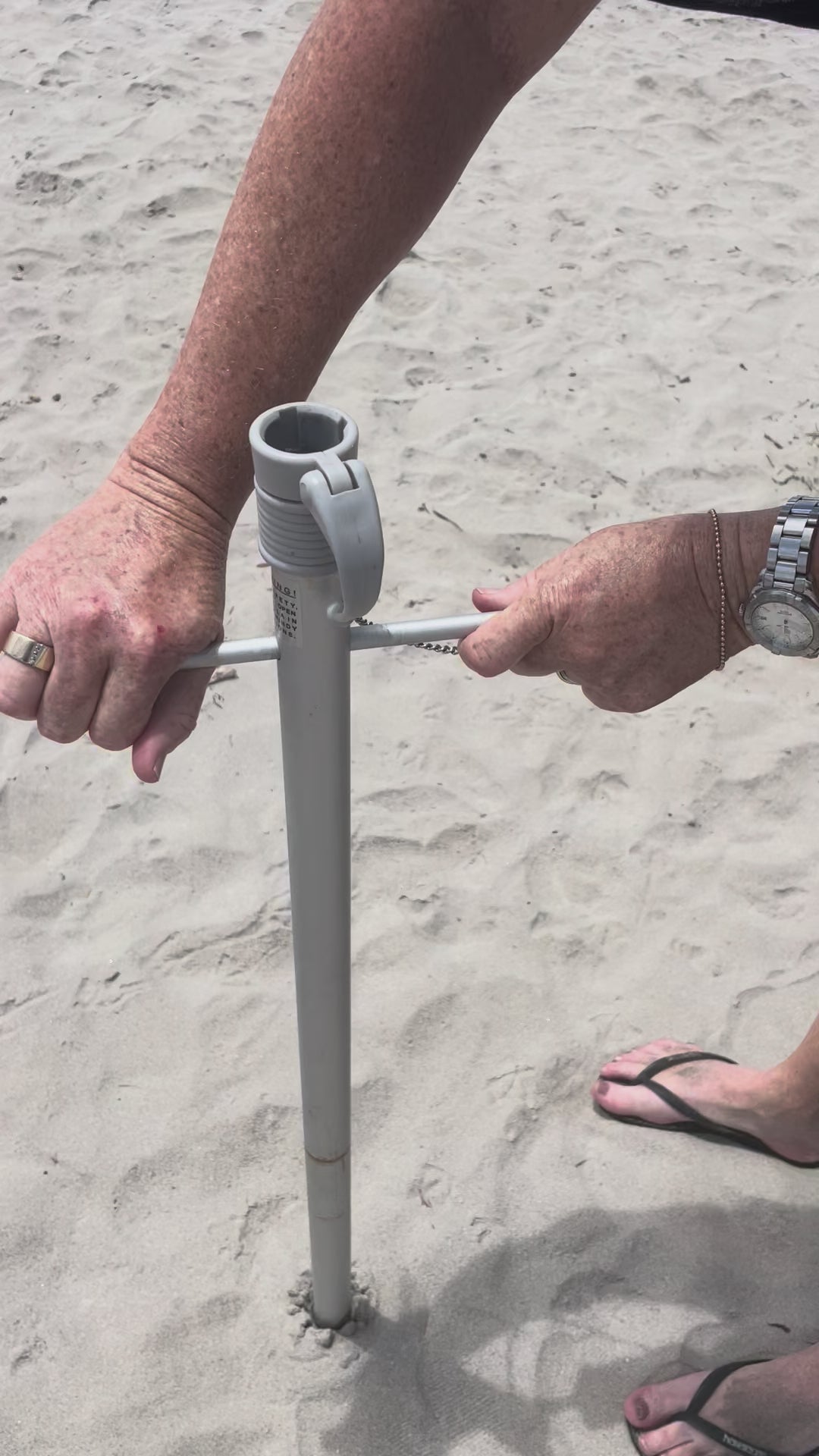 Quik Twist self-anchoring auger screwing a Beachkit umbrella into the sand