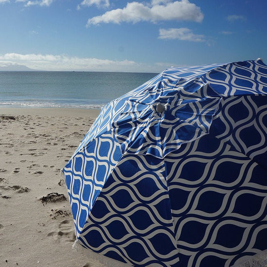 Classic Fringe Beach Umbrella in Moroccan Blue with 210cm cotton canopy and retro fringe on sandy beach