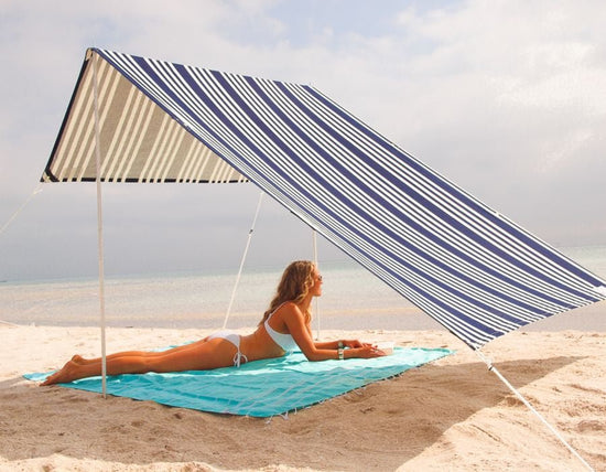 Lovin Summer Sombrilla shade tent with blue and white stripes on sandy beach